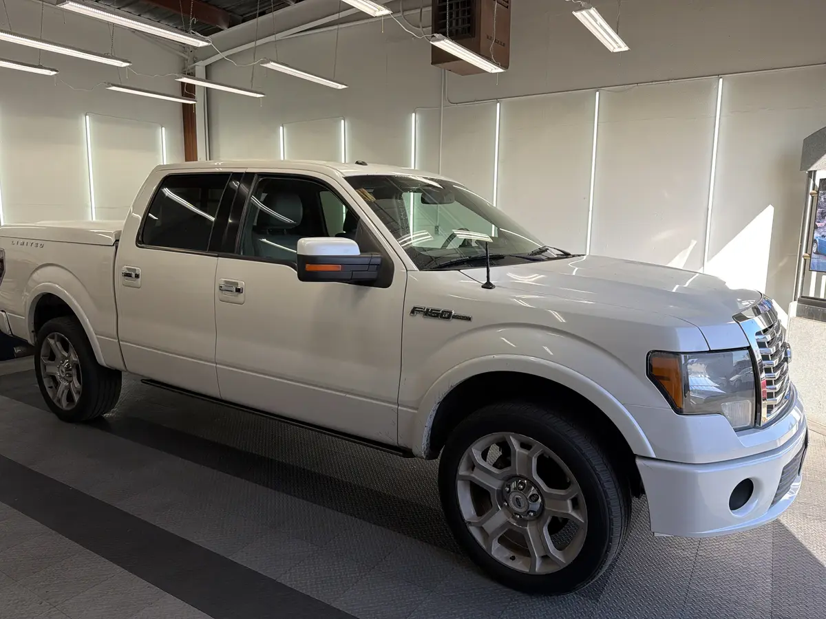 White Ford F-150 before window tinting, factory glass (view 1)