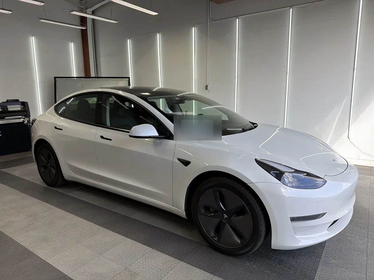 White Tesla Model 3 before window tinting, factory glass (view 1)