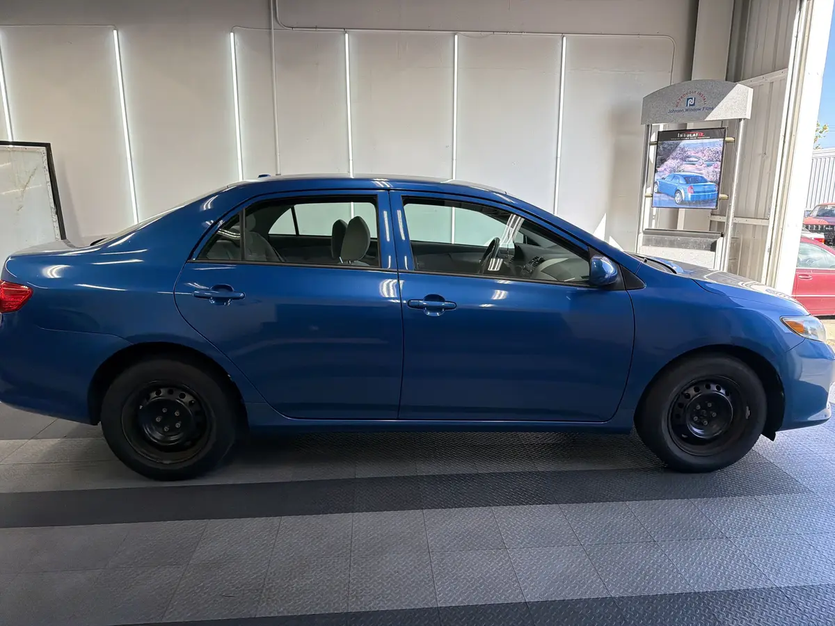 Blue Toyota Corolla before window tinting, factory glass (view 2)