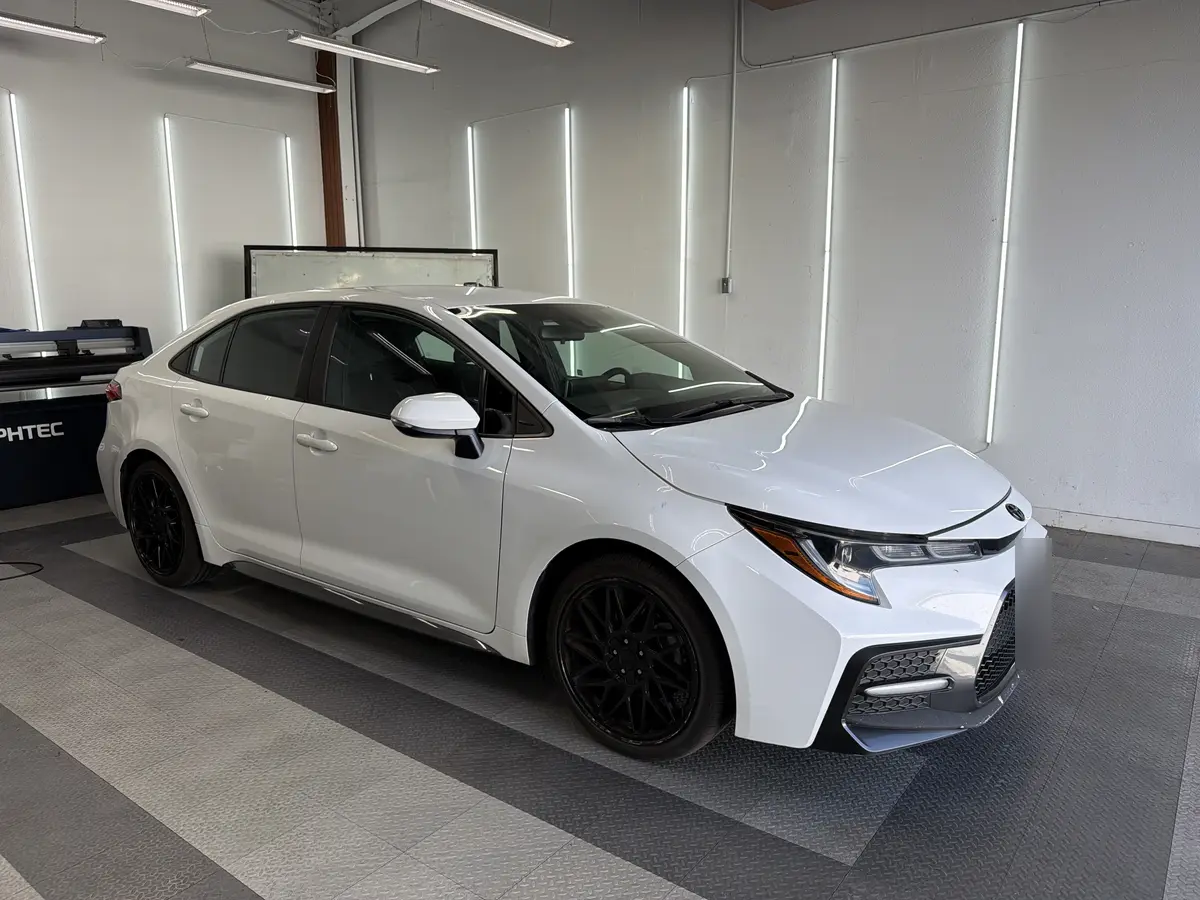 White Toyota Corolla before window tinting, factory glass (view 1)