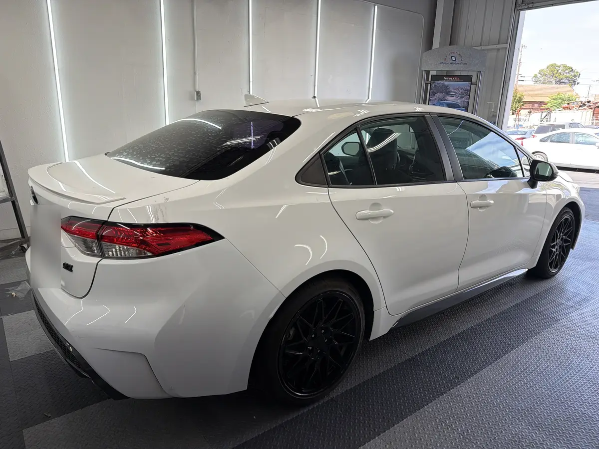 White Toyota Corolla before window tinting, factory glass (view 3)