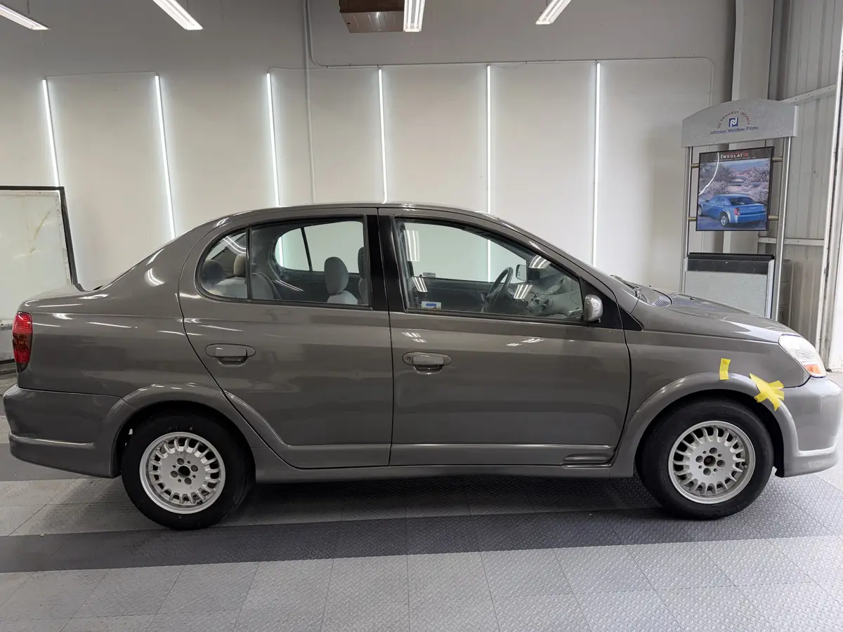 Gray Toyota Echo before window tinting, factory glass (view 2)