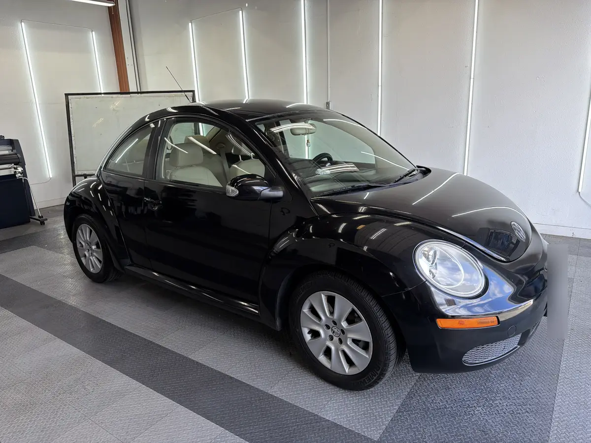 Black Volkswagen Beetle before window tinting, factory glass (view 1)